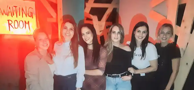 Ekipa igračica se smeši u Waiting Room prostoriji pre početka escape room igre — Door 404 Novi Sad