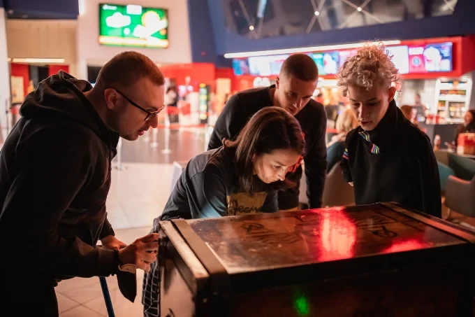 Posetioci rešavaju zagonetku na kovčegu u holu bioskopa, uz game mastera Door 404