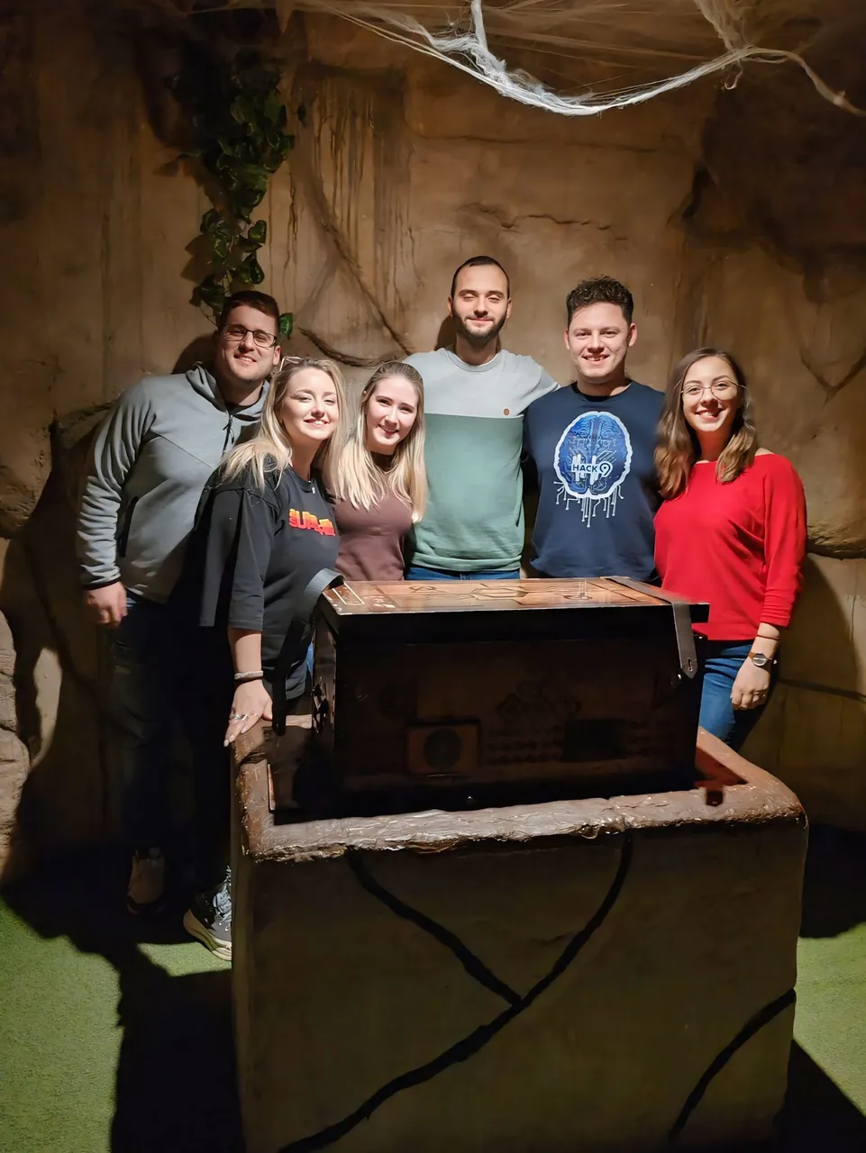 Tim od šestoro kolega oko otvorenog kovčega u sobi Kutija Izgubljenih Legendi — team building u Novom Sadu